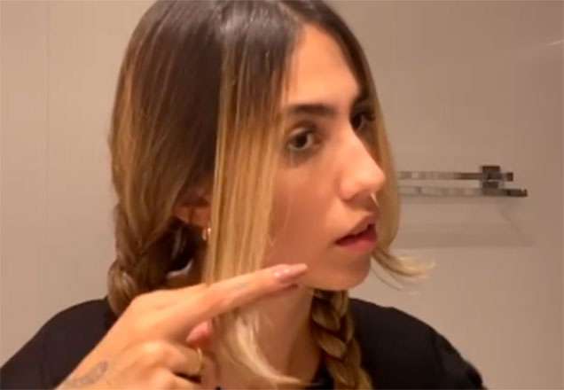 Gabi Brandt cortando o próprio cabelo